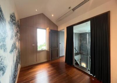 Well-lit hallway with wooden floors and dark curtains