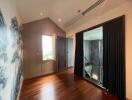 Well-lit hallway with wooden floors and dark curtains