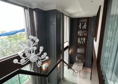 Modern stairway with large windows and a unique chandelier