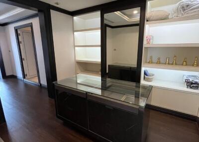 Modern dressing room with built-in shelves and glass-covered island