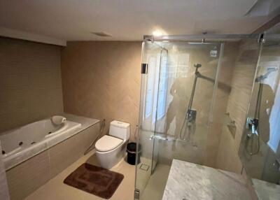 Modern bathroom with a bathtub, toilet, and glass shower