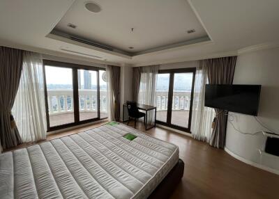 Spacious bedroom with multiple windows offering a city view