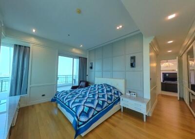 Spacious bedroom with bed, nightstands, and large windows