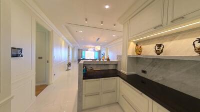 Modern kitchen with marble countertops and view into spacious living area