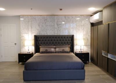 Modern bedroom with marble accent wall and stylish furniture