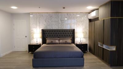 Modern bedroom with marble accent wall and stylish furniture