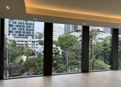 Spacious living area with large floor-to-ceiling windows and city view