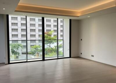 Spacious living room with large windows and modern lighting