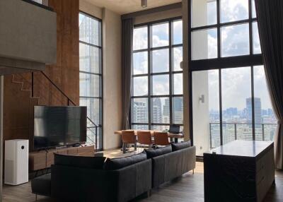 Modern living room with tall windows and city view