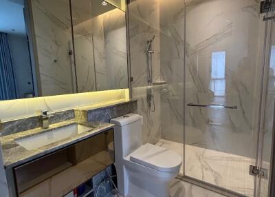 Modern bathroom with marble tiles and a glass-enclosed shower