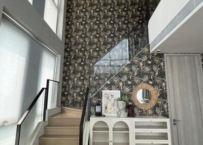 Modern hallway with staircase, patterned wall, and decorative elements