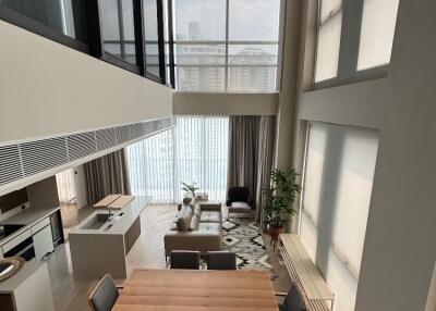 Titled view of a modern living room and dining area with large windows