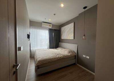 Modern bedroom with a double bed, air conditioning, and natural light through a window