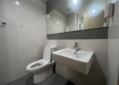 Modern bathroom with large mirror and white fixtures