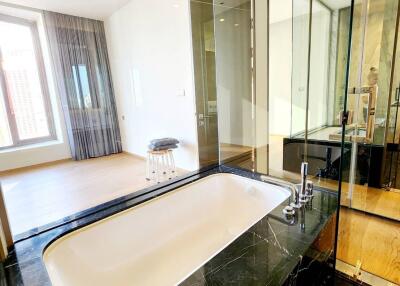 Modern bathroom with glass partition and view of bedroom