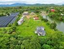 Aerial view of a property with buildings, greenery, and a water body