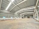 Spacious industrial warehouse with high ceilings and ample natural light.