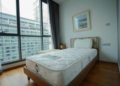 Modern bedroom with large windows and single bed