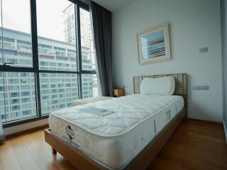 Modern bedroom with large windows and single bed