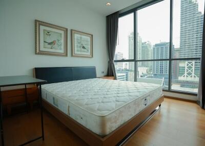 Modern bedroom with a large window and city view