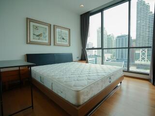 Modern bedroom with a large window and city view