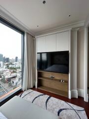 Modern bedroom with large window and wall-mounted TV