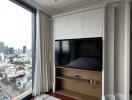 Modern bedroom with large window and wall-mounted TV