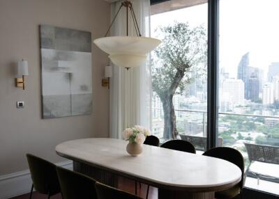 Dining area with an oval table, chandelier, city view, and large windows