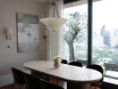 Dining area with an oval table, chandelier, city view, and large windows