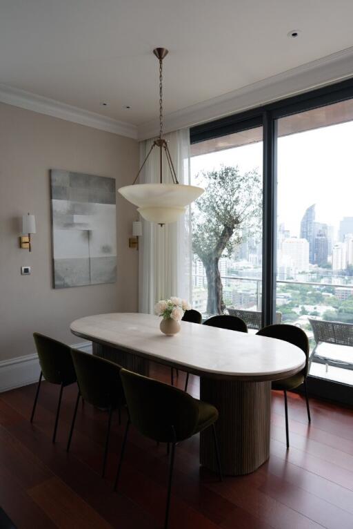 Dining area with an oval table, chandelier, city view, and large windows