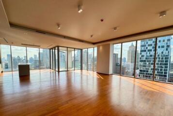 Spacious living room with floor-to-ceiling windows and city views