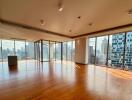 Spacious living room with floor-to-ceiling windows and city views