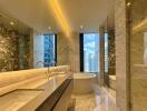 Modern bathroom with a large tub, double sinks, and marble finishes