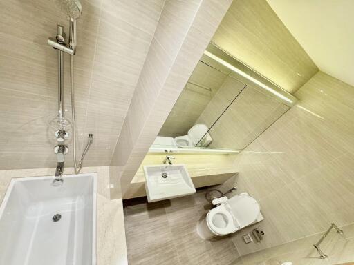 Modern bathroom with bathtub, sink, and toilet