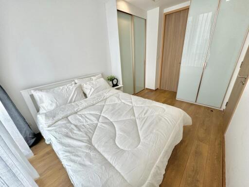 Modern bedroom with wooden floor and white bedding