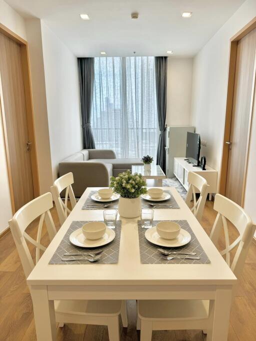 Modern dining room set up with a view of the living area