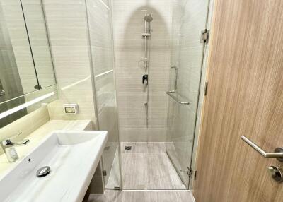 Modern bathroom with glass shower enclosure and wooden door