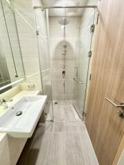 Modern bathroom with glass shower enclosure and wooden door