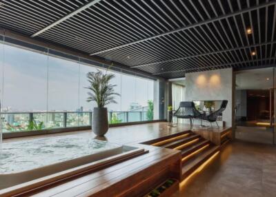 Modern living room with glass walls, pool, and city view