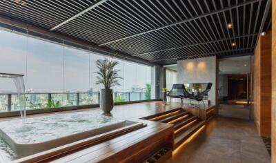 Modern living room with glass walls, pool, and city view