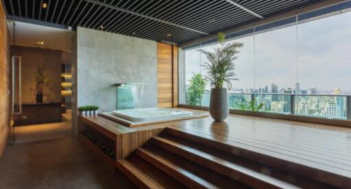 Main living space with large windows, jacuzzi, and city view