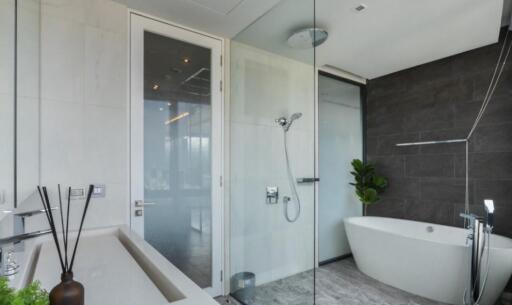 Modern bathroom with glass-enclosed shower, bathtub, and contemporary decor