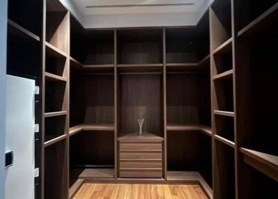 Spacious wooden walk-in closet with ample shelving and storage space