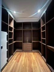 Spacious wooden walk-in closet with ample shelving and storage space