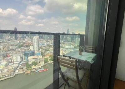 Balcony overlooking cityscape with outdoor table and chair