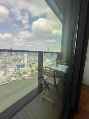 Balcony overlooking cityscape with outdoor table and chair