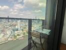 Balcony overlooking cityscape with outdoor table and chair