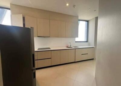 Modern kitchen with built-in cabinets, large window, and stainless steel refrigerator