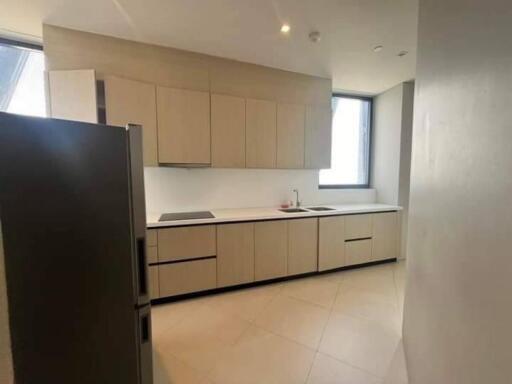 Modern kitchen with built-in cabinets, large window, and stainless steel refrigerator