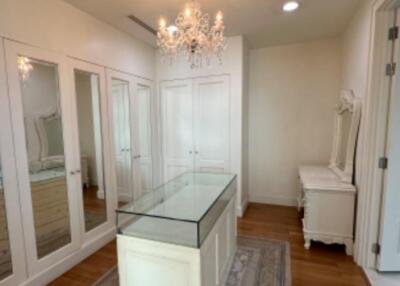 Spacious walk-in closet with chandelier and multiple mirrors